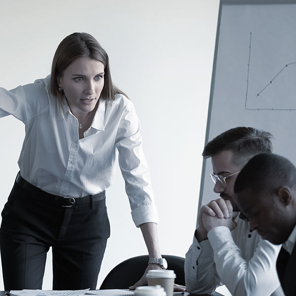 Woman berating two male employees