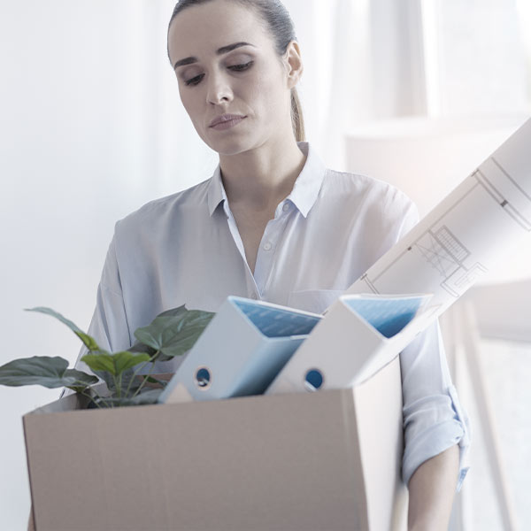 Woman carrying items from her desk of cardboard box
